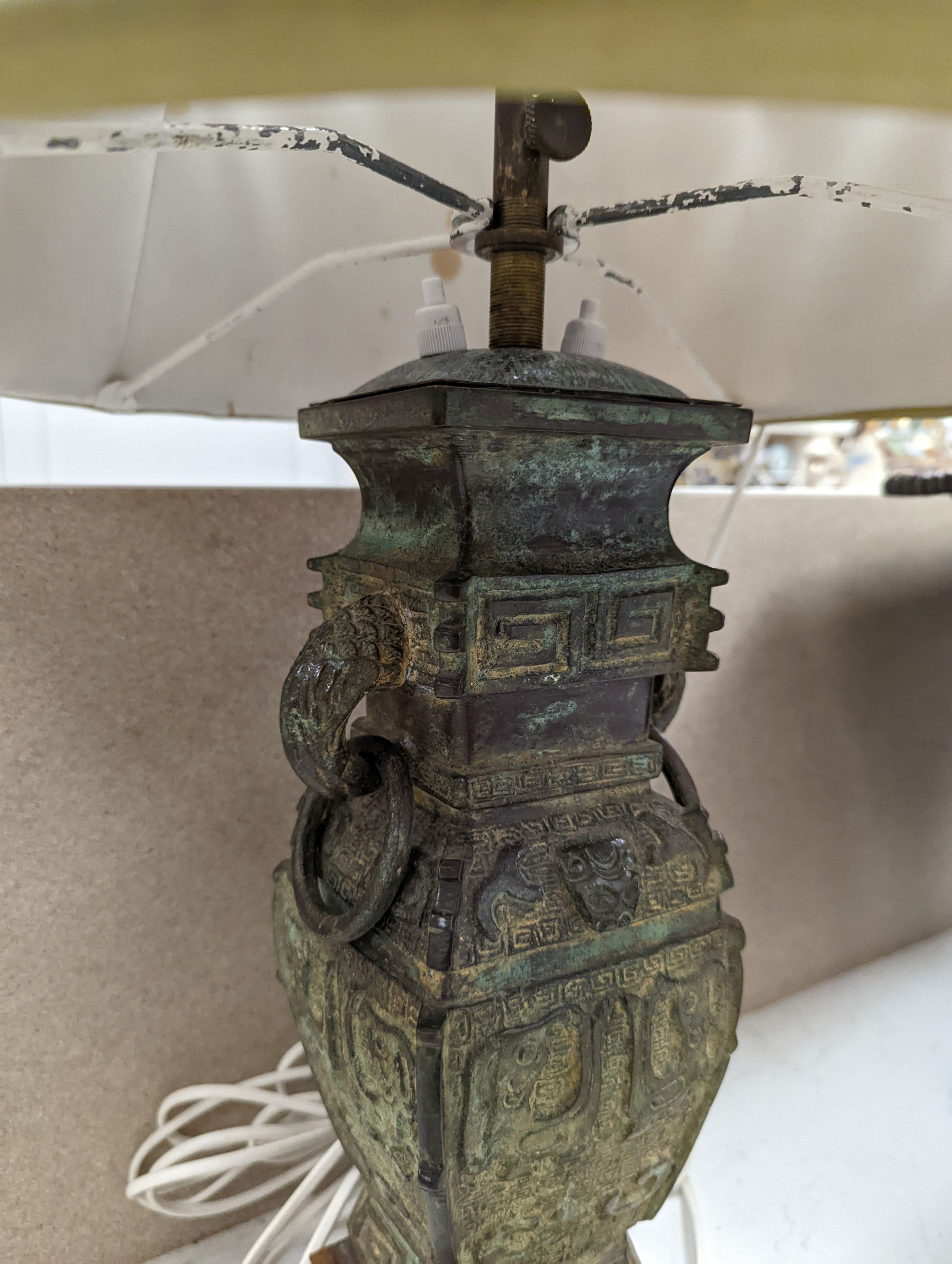 A pair of Chinese archaistic bronze lamps, 37 cms high not including shades or light fitting.